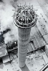 Helicopter view of tall factory smokestack